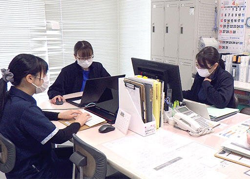 写真：デスクワークをしている3人の職員
