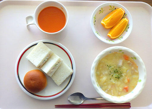 写真：食事：サンドイッチ、パン、スープ、ジュースとオレンジ